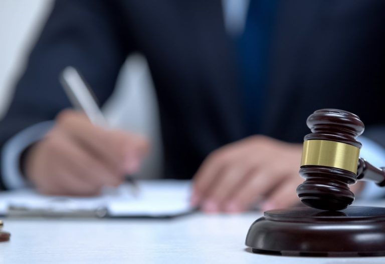 Gavel on block as jurisdictional symbol, attorney signing eviden